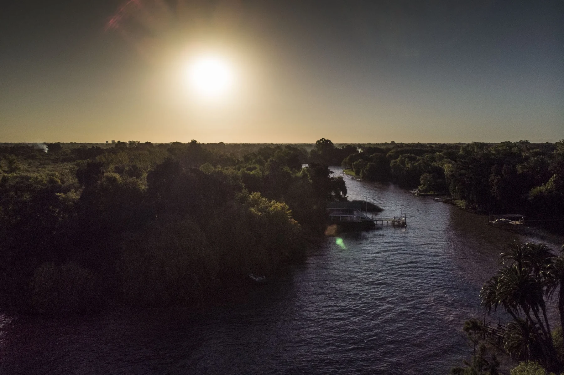 El sol desciende sobre el río y los árboles del Delta